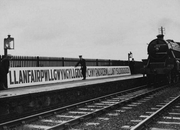 Установка таблички на железнодорожной станции Лланфайрпуллгвингиллгогерыхверндробуллллантисилйогогогох в Уэльсе, Великобритания. Первая половина XX века. В столице Великобритании Лондоне можно